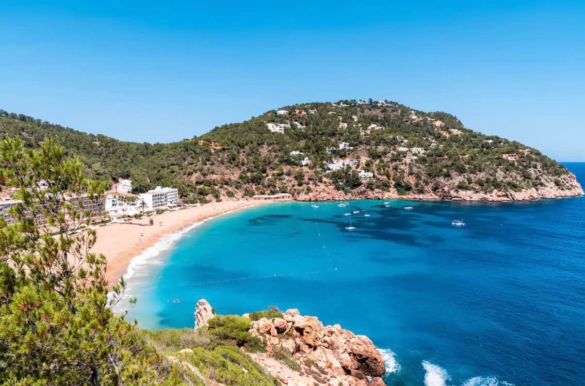 A turquoise cove with a sandy beach on the coast of Ibiza