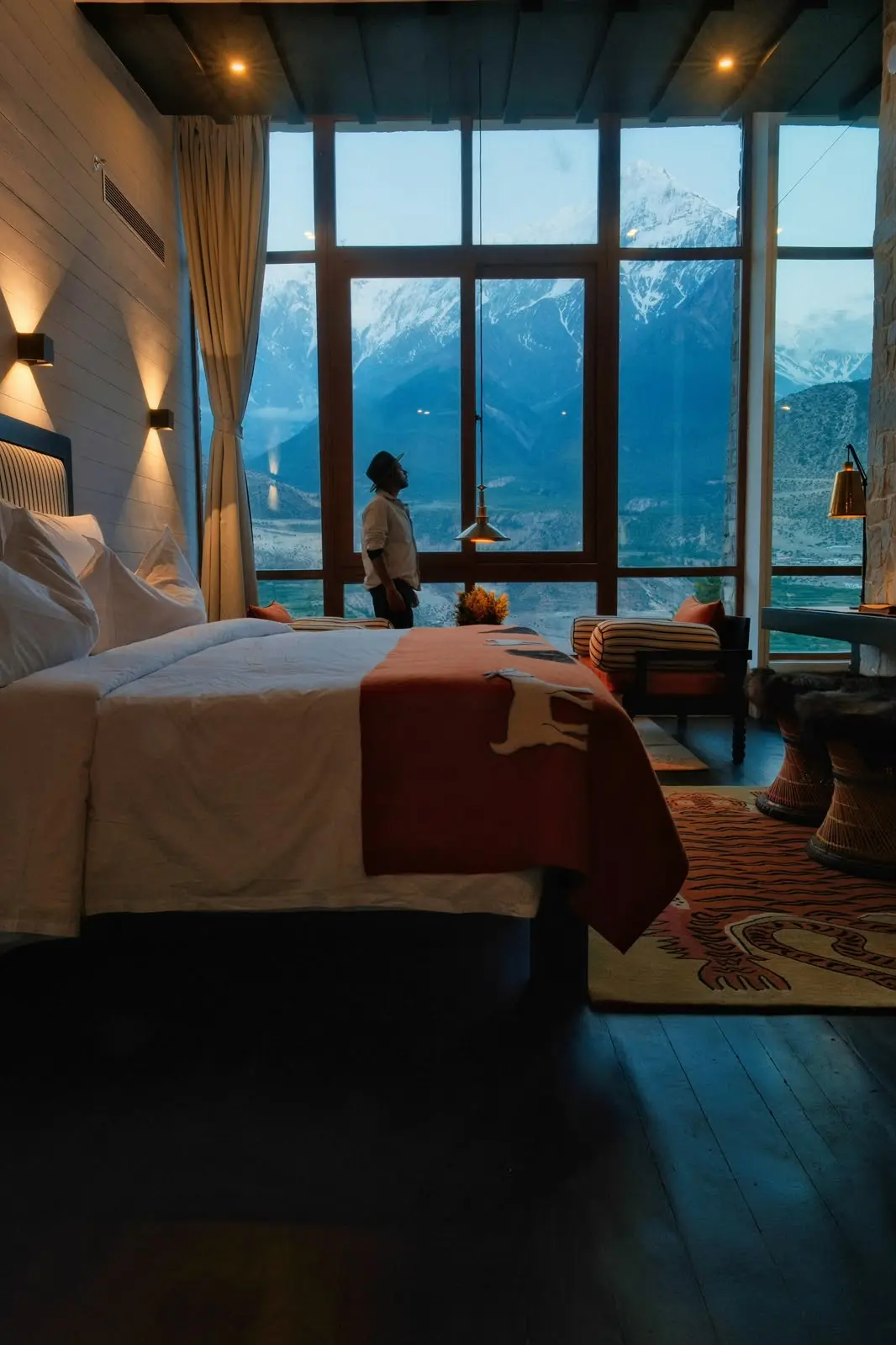 Hotel suite with floor-to-ceiling windows facing snow-capped mountains